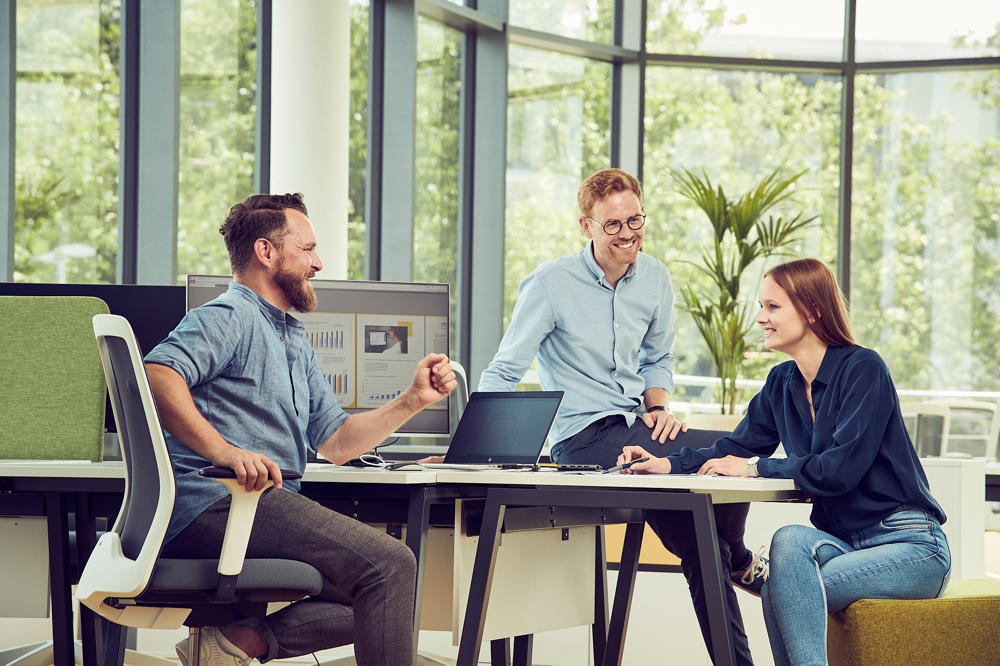 Foto von Menschen, die vor einem Laptop sitzen